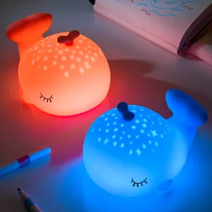 Détail de veilleuse baleine en silicone avec texture douce et projection d'étoiles colorée.