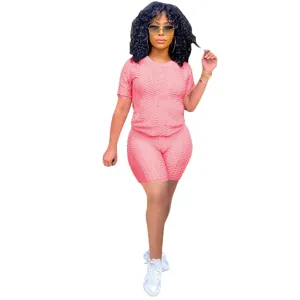 Completo sportivo da donna rosa in due pezzi con top a maniche corte e pantaloncini.