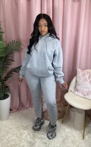 Detailaufnahme des gemütlichen Kapuzenpullover und Jogginghose Sets im warmen Innenbereich.