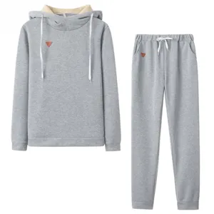 Grey fleece hoodie and sweatpants two-piece set detail view with small leather patch.