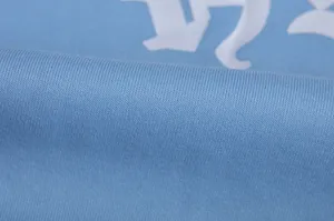 Hellblaue Kapuzenpullover Stoff Detailaufnahme mit weicher Stricktextur und weissem Druck.