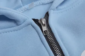 Nahaufnahme des Metallreißverschlusses an einem stylischen hellblauen Damen Kapuzenpullover.