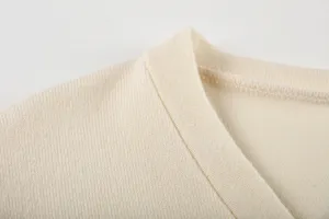 Vue détaillée du col en tricot beige, présentant une texture fine et des coutures nettes.