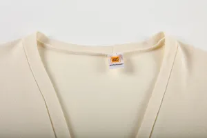 Détail de col de top en tricot beige, texture de tissu haut de gamme, style décontracté basique.