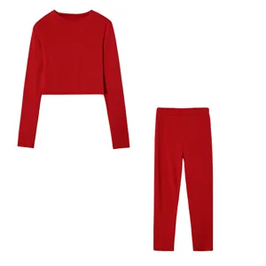 Detailed view of the vibrant red long-sleeve crop top and matching slim pants outfit.