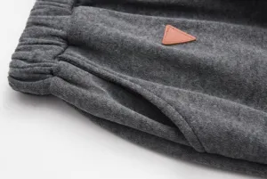 Dark grey fleece sweatpants detail, elastic waistband and pocket with leather patch.