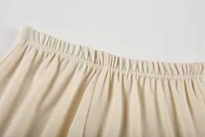 Détail en gros plan de la taille élastique d'un pantalon en tricot beige doux.