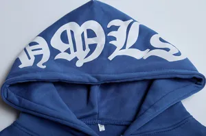 Nahaufnahme Detail des blauen Damen Streetwear Hoodies mit gotischem Buchstabenprint.