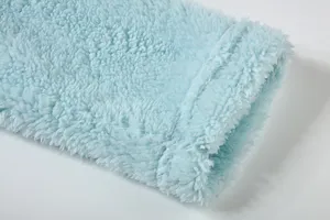 Close-up detail of light blue plush fleece fabric, soft texture winter cozy apparel.
