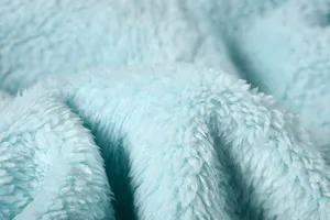 Light blue plush fleece fabric close-up, soft fluffy texture detail for cozy winter sweatshirt apparel.