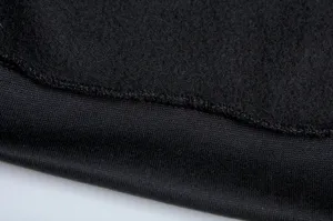 Detaillierte Nahaufnahme des schwarzen Fleece-Stoffs mit sauberem Rippsaum und Nähten.