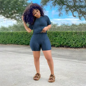 Completo sportivo a maniche corte strutturato blu scuro con top girocollo e pantaloncini.