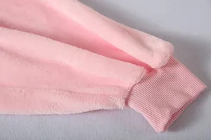 Détail de manche de peignoir en polaire rose, vue rapprochée du tissu doux et douillet.