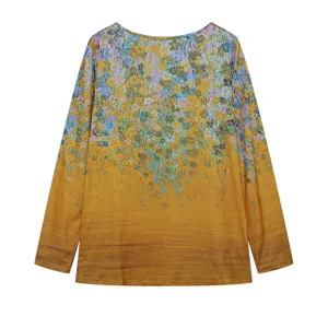 Detailed view of women's long sleeve top, gradient yellow fabric with blue floral print.