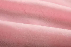 Gros plan détaillé du tissu polaire rose doux, mettant en valeur sa texture moelleuse.