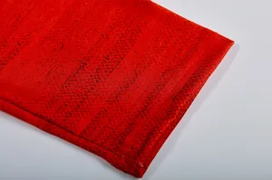 Detailed view of red patterned long sleeve top fabric texture, clean studio product shot.