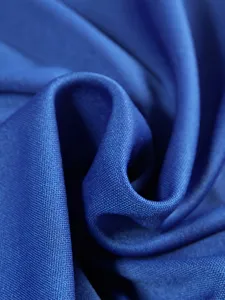 Primo piano di tessuto strutturato blu, ideale per abbigliamento elegante e sportswear.