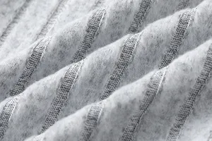 Knitted fabric detail close-up, soft texture and vertical ribbed design for comfortable apparel.