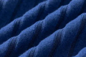Close-up detail of soft blue knitted fabric featuring ribbed texture, premium apparel material.