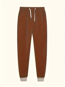 Dettaglio pantaloni tuta casual da donna marroni, con coulisse e polsini a righe.