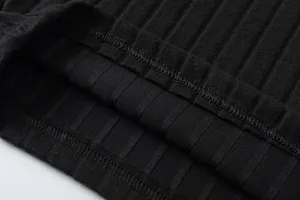 Close-up detail of black ribbed knit fabric showing fine texture and clean stitching.