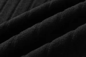 Black knitted fabric detail shot featuring soft ribbed texture and comfortable autumn material.