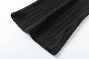 Close-up detail of black ribbed knit fabric texture, showing elastic cuff or hem design.