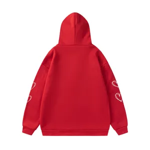 Vue détaillée du sweat à capuche rouge avec de jolies impressions de cœur sur les manches.
