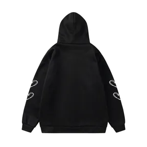 Vue détaillée de la manche du sweat à capuche noir avec un design d'imprimé cœur blanc unique.