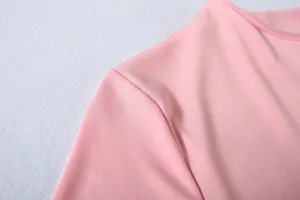 Close-up detail view of women pink long sleeve top showing shoulder seam and fabric texture.