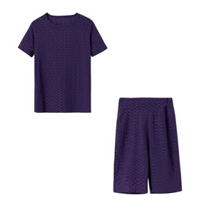 Completo sportivo donna top manica corta viola con motivo alveolato e pantaloncini.