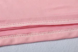 Close up view of pink athletic apparel fabric showing neat white overlock stitching details.