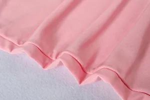 Close-up of pink soft knit fabric texture, showing smooth material details for apparel.