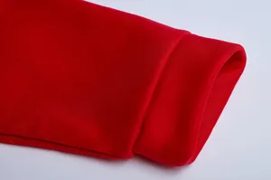 Nahaufnahme des roten Kapuzenpullover-Ärmelabschlusses mit weicher Strickgewebestruktur.