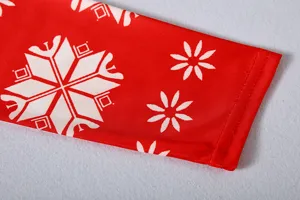 Gedetailleerd close-upgezicht van de rode kerstjurkmouw met witte sneeuwvlokken.