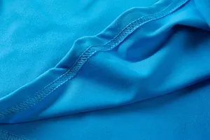 Κοντινή λήψη υφάσματος μπλε γυναικείας μπλούζας με μακριά μανίκια και προσεγμένες ραφές.