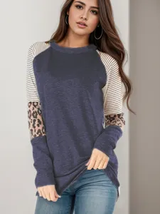 Detailed view of women's long-sleeve crewneck top featuring stylish striped and leopard color block.