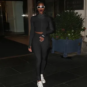 Μαύρο ριμπ αθλητικό σετ γυμναστικής με crop top μακρυμάνικο και εφαρμοστό γυναικείο κολάν.