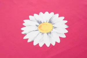 Close-up detail shot of vibrant pink fabric featuring a large white daisy flower print.