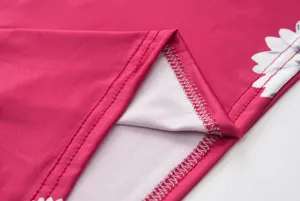 Close-up detail of women's floral print dress fabric, showing fine stitching and soft texture.