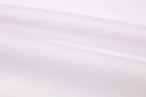 Close-up view of soft white knitted fabric texture, showing fine weave and comfortable material.