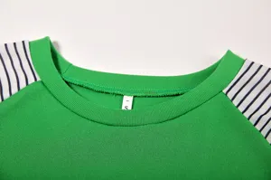 Detail shot of green long sleeve t-shirt with black and white striped raglan sleeves.