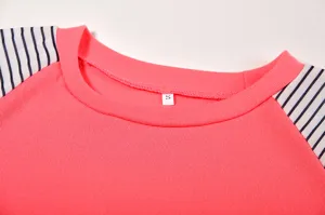 Detail view of women's crewneck long sleeve t-shirt, pink body with striped raglan sleeves.