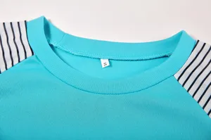 Close-up detail of women's turquoise crewneck long sleeve t-shirt with striped sleeves.