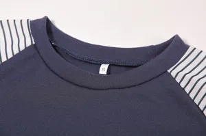 Close-up detail of dark blue crewneck long sleeve t-shirt with striped raglan sleeves.