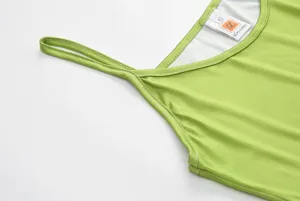 Detail shot of green camisole dress neckline with double thin straps and branded tag inside.