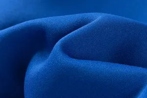 Gros plan sur les details du tissu bleu roi montrant une texture douce et fine de qualite.