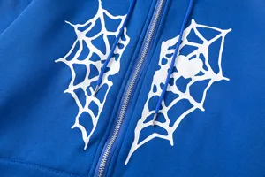 Détail de sweat à capuche bleu avec imprimé graphique cœur toile d'araignée blanche.