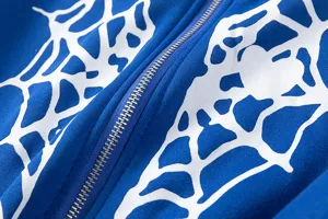 Sweat à capuche bleu avec imprimé toile d'araignée blanche et détail de fermeture éclair métallique.