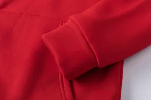 Gros plan sur les détails des poignets du sweat à capuche rouge polaire fin.